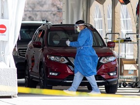 A frontline health-care worker attends people at the Etobicoke General Hospital drive-thru COVID-19 assessment centre as the number of coronavirus disease (COVID-19) cases continue to grow, in Toronto on April 9, 2020.