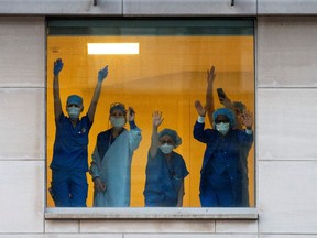 Healthcare workers clap and wave as Toronto Police and the city's front-line responders pay tribute to healthcare workers along University Avenue as the number of coronavirus disease (COVID-19) cases continue to grow in Toronto, Ontario, Canada April 19, 2020.