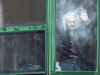 A resident waves from her window at Residence Herron, a senior’s long-term care facility, following a number of deaths since the COVID-19 outbreak, in Montreal, April 13, 2020.