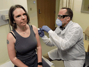 A pharmacist on March 16 gives Jennifer Haller the first shot in the first-stage safety study clinical trial 
of a potential vaccine for COVID-19, the disease caused by the new coronavirus.