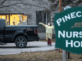 Workers wave at passing cars honking their horns in support for Pinecrest Nursing Home after several residents died and dozens of staff were sickened by COVID-19 in Bobcaygeon. Ont.