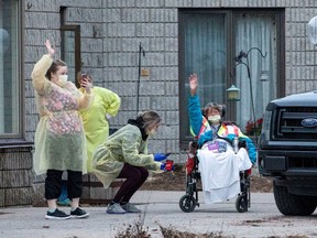 Workers and a resident wave at passing cars honking their horns in support for Pinecrest Nursing Home after several residents died and dozens of staff were sickened by coronavirus disease (COVID-19) in Bobcaygeon, Ontario, Canada March 30, 2020.