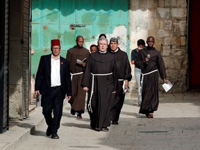 Father Francesco Patton, the Custos of the Holy Land for the Roman Catholic church and other Franciscan friars walk towards the Church of the Holy Sepulchre amid the coronavirus disease (COVID-19) outbreak in Jerusalem's Old City March 27, 2020