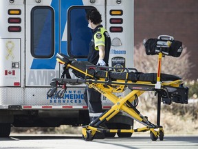 A paramedic returns a stretcher to his ambulance at Toronto Western Hospital, April 1, 2020.