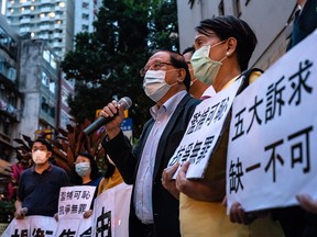 Pro-democracy supporters shout slogans outside the Western District police station in Hong Kong after at least 14 pro-democracy veterans and supporters were arrested in a sweeping operation on April 18, 2020.