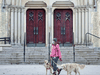 A woman wearing a mask walks her dogs in front of Toronto’s Metropolitan United Church during the COVID-19 pandemic.