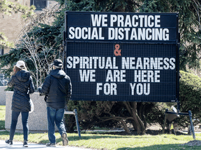 A couple walk past a Toronto synagogue during the COVID-19 pandemic.