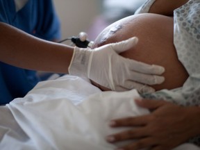 A pregnant woman is examined as she waits to give birth at a public hospital in Rio de Janeiro on Wednesday, July 25, 2012.