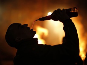 In this photo taken on Thursday, Jan. 16, 2020, a man drinks wine during a ritual in honor of Saint Anthony the Abbot, the patron saint of domestic animals, in San Bartolome de Pinares, Spain. Research is shedding new light on old stories about the relationship between animals and alcohol.