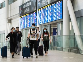 People arrive at Pearson International Airport in Toronto on Monday, March 16, 2020. As of midnight, all people returning to Canada will have to check in to a hotel or other designated site unless they have an acceptable self-quarantine plan.THE CANADIAN PRESS/Nathan Denette