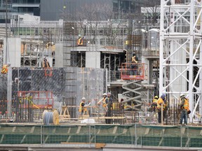 Workers are shown at a construction site in Toronto on Wednesday, March 18, 2020. Cities and construction groups are asking the Trudeau Liberals to relax rules or directly fund expected cost overruns from infrastructure projects facing delays from the COVID-19 pandemic.