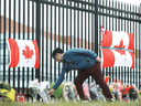 A person leaves flowers at a make-shift memorial dedicated to Constable Heidi Stevenson at RCMP headquarters in Dartmouth, Nova Scotia, April 20, 2020.