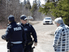 RCMP officers speak with a man in Portapique, Nova Scotia, after search for mass shooting suspect Gabriel Wortman ended on April 19, 2020.