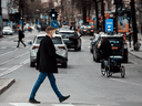 A pedestrian wearing a protective face mask crosses a busy street on April 16, 2020 in Stockholm, during the coronavirus COVID-19 pandemic.