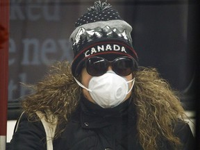 A commuter wears a mask on the subway in Toronto to ward off COVID-19, on April 1, 2020.
