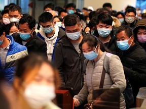 Passengers wearing face masks arrive at a railway station in Wuhan, China, on the first day inbound train services resumed following the COVID-19 outbreak, on March 28, 2020.