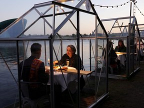 Diners are seen at a restaurant as servers receive training in providing drinks and food in safe "quarantine greenhouses" in Amsterdam, Netherlands on May 5, 2020.