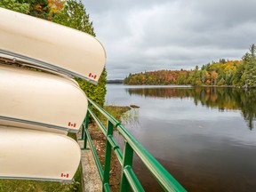 Canoes Stored on a Rack Overlooking a Lake in Autumn