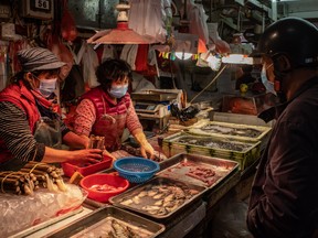 Residents wearing face masks purchase seafood at a wet market on January 28, 2020 in Macau, China.