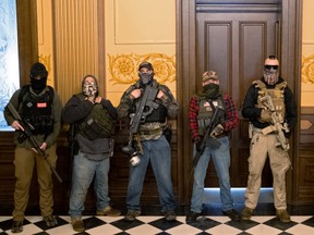 A militia group from Michigan stands in front of the governor's office after protesters occupied the state capitol building during a vote to approve the extension of Governor Gretchen Whitmer's emergency declaration/stay-at-home order due to the coronavirus disease (COVID-19) outbreak, at the state capitol in Lansing, Michigan, U.S. April 30, 2020.