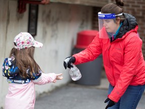 A student has hands sanitized in the schoolyard as schools reopen outside the greater Montreal region in Saint-Jean-sur-Richelieu.