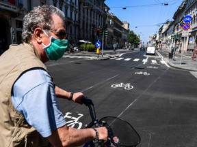 A man rides a bicycle through a bike lane in central Milan on May 4, 2020, as Italy starts to ease its lockdown, during the country's lockdown aimed at curbing the spread of the COVID-19 infection, caused by the novel coronavirus.