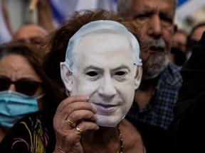 Supporters of Israeli Prime Minister Benjamin Netanyahu wearing protective masks against the coronavirus disease (COVID-19) take part in a protest outside the Prime Minister's Residence, on the day when Netanyahu's corruption trial starts, in Jerusalem May 24, 2020.
