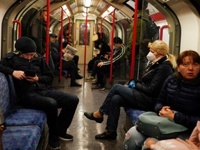Commuters, some wearing masks are seen on a London Underground train, following the outbreak of the coronavirus disease (COVID-19), London, Britain, May 13, 2020.
