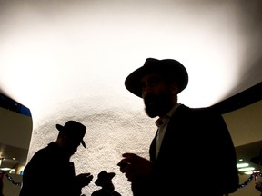 Orthodox Jews are silhouetted against the rotunda in City Hall during the Chanukah event called 'Occupy City Hall' in Toronto on Sunday, December 9, 2012.