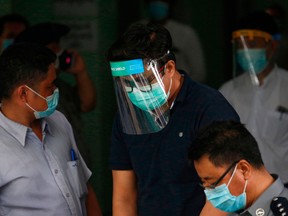 Canadian Christian pastor David Lah (C) wears a mask and face shield at Mayangone Township Court in Yangon on May 20, 2020, as he faced charges over allegedly organizing religious gatherings despite a ban on mass events to halt the spread of the COVID-19 coronavirus.