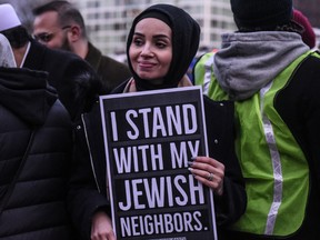 A demonstrator holds a sign that reads 'I STAND WITH MY JEWISH NEIGHBORS' during a rally on December 31, 2019 in the Brooklyn borough of New York City.