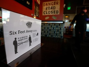 A sign about keeping six feet away is seen in Bad Daddy's Burger Bar as it reopened for dine-in seating on April 27, 2020 in Decatur, Georgia.