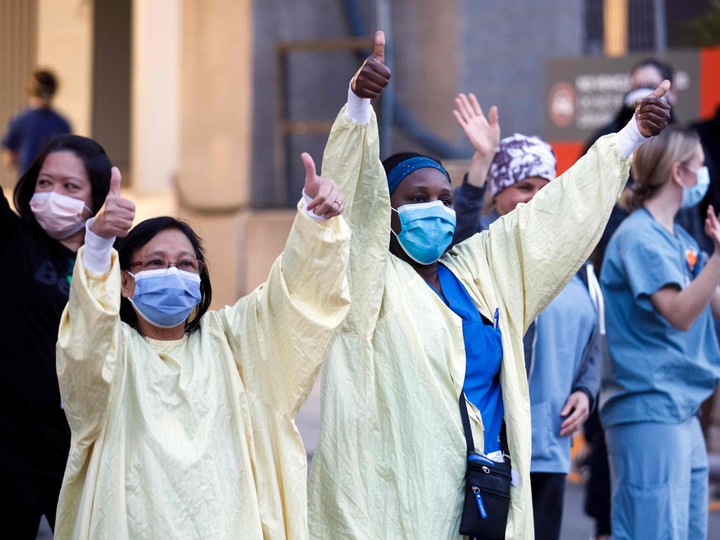  Healthcare workers cheer as Toronto first responders parade down hospital row in Toronto, Ontario, Canada, in a salute to healthcare workers on April 19, 2020, amid the novel coronavirus pandemic.