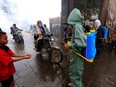 A Yemeni municipal worker sprays disinfectant liquid as a measure against the novel coronavirus, in the old city market of the capital Sanaa, on April 30, 2020.