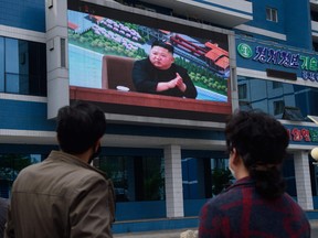 People watch a broadcast of North Korean leader Kim Jong Un in Pyongyang on May 2.