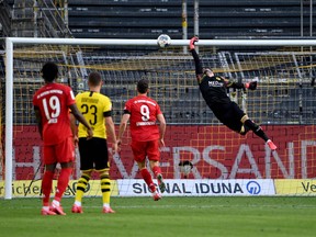 Dortmund's Swiss goalkeeper Roman Buerki fails to keep out the opening goal scored by Bayern Munich's German midfielder Joshua Kimmich during the German first division Bundesliga football match BVB Borussia Dortmund v FC Bayern Munich on May 26, 2020 in Dortmund, western Germany.