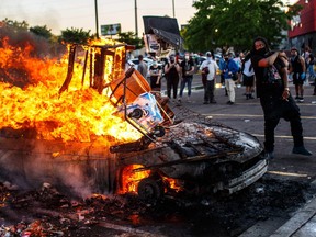 Protesters throw objects into a fire outside a Target store near the Third Police Precinct on May 28, 2020 in Minneapolis, Minnesota, during a demonstration over the death of George Floyd.