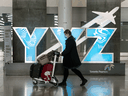 A person wearing a mask walks through Toronto Pearson Airport's Terminal 1 on May 20, 2020.
