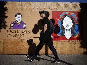People walk by a mural of sign-language interpreter Nigel Howard and Chief Public Health Officer Dr. Theresa Tam created by artist Ian Morris seen along Government St. in Victoria, B.C., on Wednesday May 6, 2020.