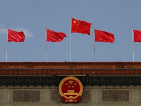 A Chinese flag flutters above the Chinese national emblem at the Great Hall of the People after the opening session of the National People's Congress in Beijing on May 22.