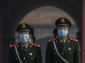 Chinese paramilitary police wear protective masks as they guard the entrance to the Forbidden City as it re-opened to limited visitors for the May holiday, on May 1, 2020 in Beijing, China.