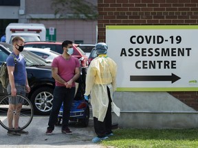 People line up to be tested at a COVID-19 assessment centre in Toronto on Tuesday, May 26, 2020.