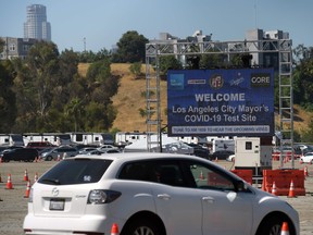 People line up in their cars at a drive-through novel coronavirus testing site to get a free COVID-19 test at the Los Angeles Dodgers stadium parking lot, in Los Angeles, California on May 26, 2020.