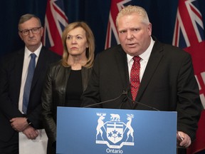 Ontario Premier Doug Ford answers questions as Minister of Health Christine Elliott and Ontario Chief Medical Officer of Health Dr. David Williams, left, listen in during a news conference at the Ontario Legislature in Toronto on  March 16.