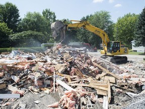 A demolition crew removes the remains of a mobile home in Sainte-Marthe-sur-le-Lac, Que., Friday, Aug. 16, 2019, following spring flooding in the area.
