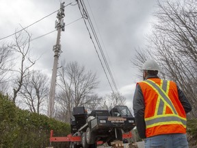 Technicians repair a cell tower after a fire that police are calling suspicious, Monday May 4, 2020, in Piedmont, Quebec. Quebec provincial police say they've arrested two people in connection with a spate of cell phone tower fires in recent days.
