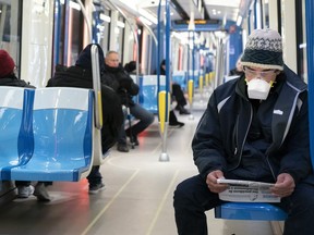 Commuters keep their distances in a subway train in Montreal, on Wednesday, April 22, 2020. Montreal's transit authority is strongly recommending that passengers wear a mask when riding the bus or subway.
