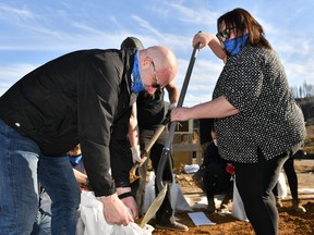 Don Scott, Mayor of the Regional Municipality of Wood Buffalo, and municipal counsellor Krista Balsom, right, help out on a sandbagging crew working to protect historic buildings from flooding at the Heritage Village in Fort McMurray, Albert on Wednesday April 30, 2020.