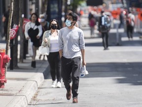 People walk along an extended sidewalk on Sainte-Catherine street in Montreal, Saturday, May 30, 2020, as the COVID-19 pandemic continues in Canada and around the world.THE CANADIAN PRESS/Graham Hughes