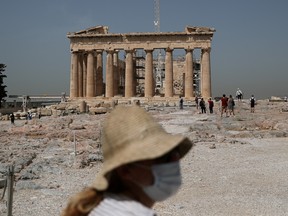A Culture ministry employee wearing a face mask stands in front of the Parthenon temple as the Acropolis archaeological site opens to visitors, following the easing of measures against the spread of the coronavirus disease (COVID-19), in Athens, Greece, May 18, 2020.